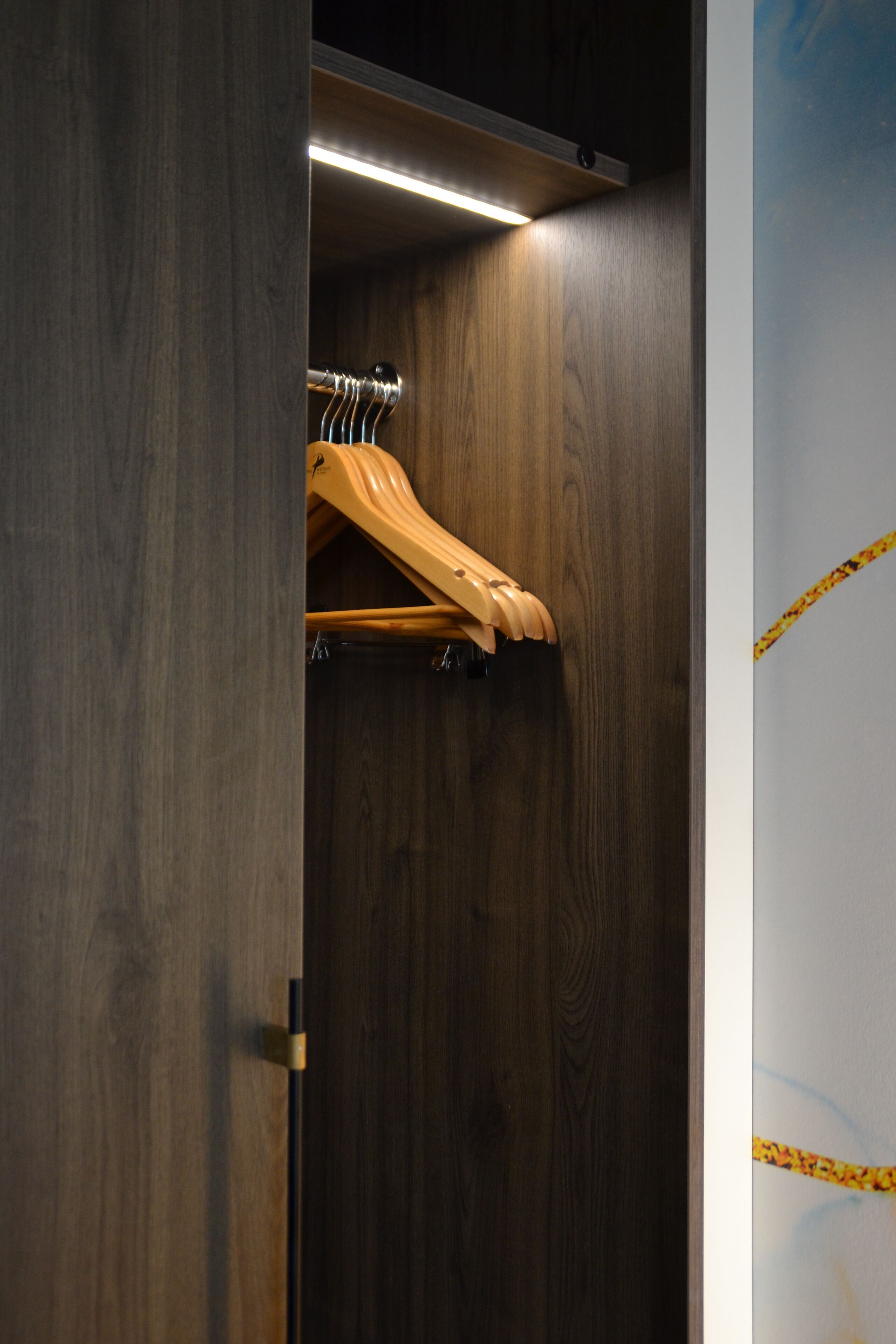 Ein Holzkleiderschrank mit Kleiderstange.