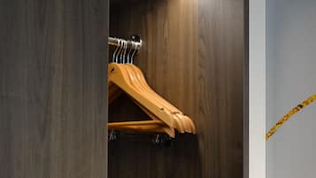 A wooden wardrobe with a hanging rack inside.