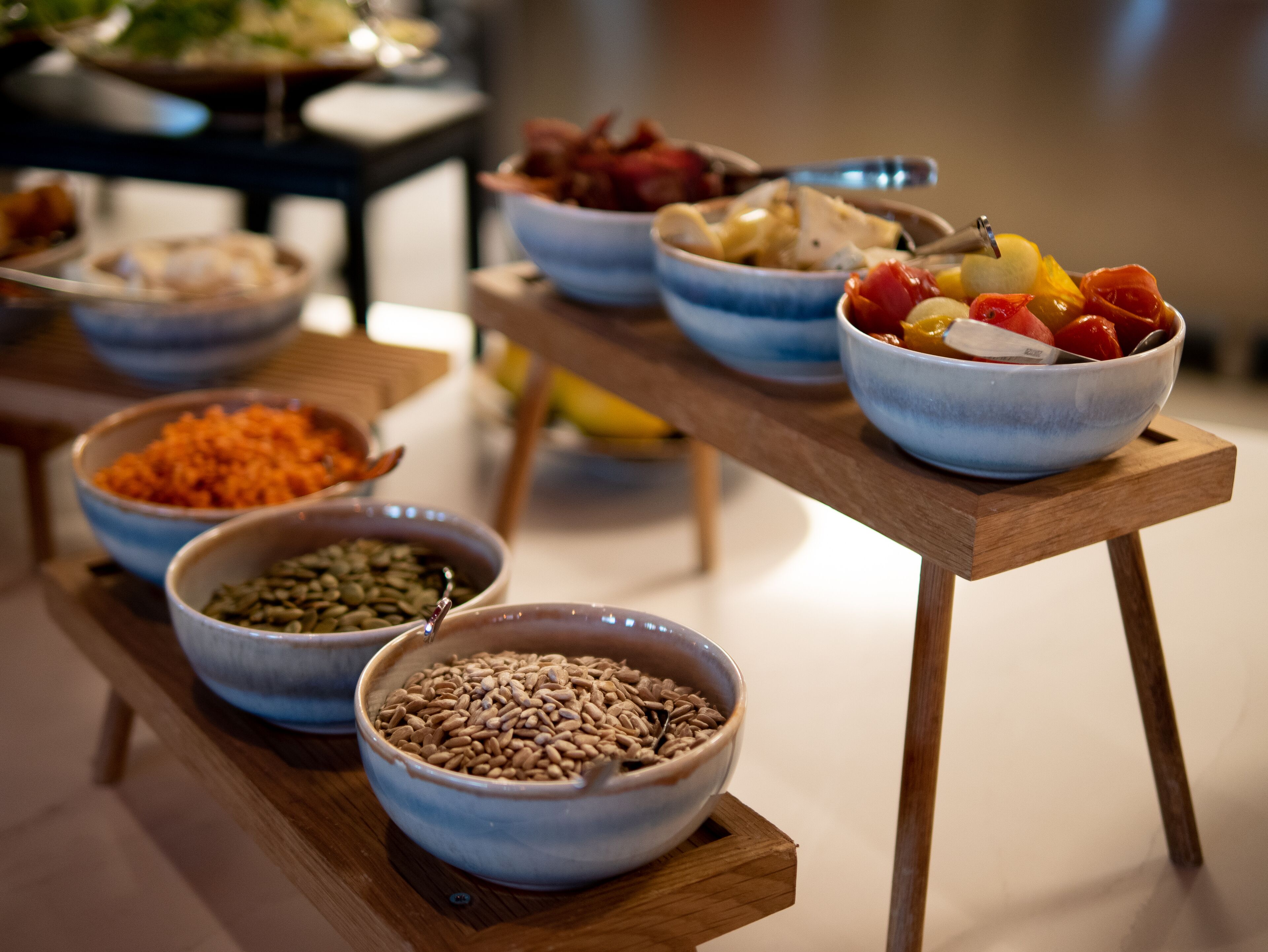 Een tafel met verschillende schalen eten, waaronder granen en fruit, gerangschikt op een houten tafel.