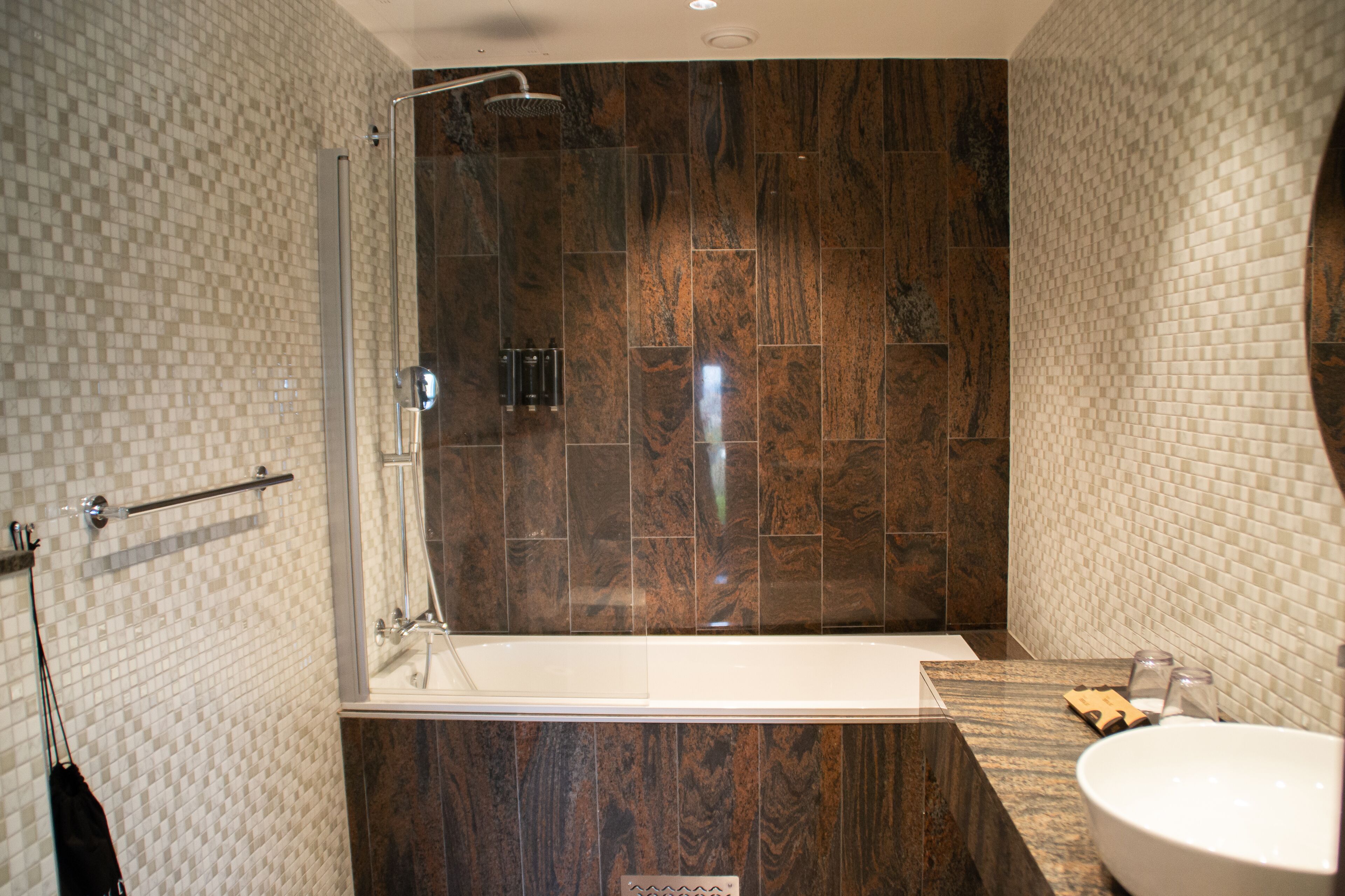 A modern bathroom with a glass-enclosed shower, a freestanding bathtub, and a marble vanity with a sink.