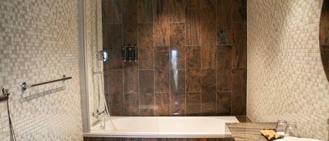 A modern bathroom with a glass-enclosed shower, a freestanding bathtub, and a marble vanity with a sink.