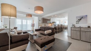 A modern living room with a sofa, ottoman, and a painting of a starfish on a stand. - Exquisite 4 BD villa for 8 with heated pool near Zadar (Sukošan)