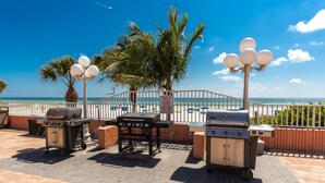 A patio with grills and a view of the ocean. - Condominium on beach (Indian Shores)