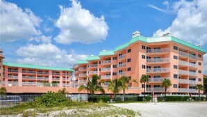 A multi-story hotel with balconies and a green roof. - Condominium on beach (Indian Shores)