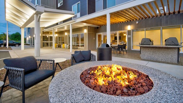 An outdoor seating area with a fire pit, outdoor furniture, and a covered patio. - TownePlace Suites by Marriott Asheville West (Asheville)