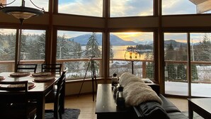 Quarto espaçoso com amplas janelas que oferecem vista para uma paisagem montanhosa.