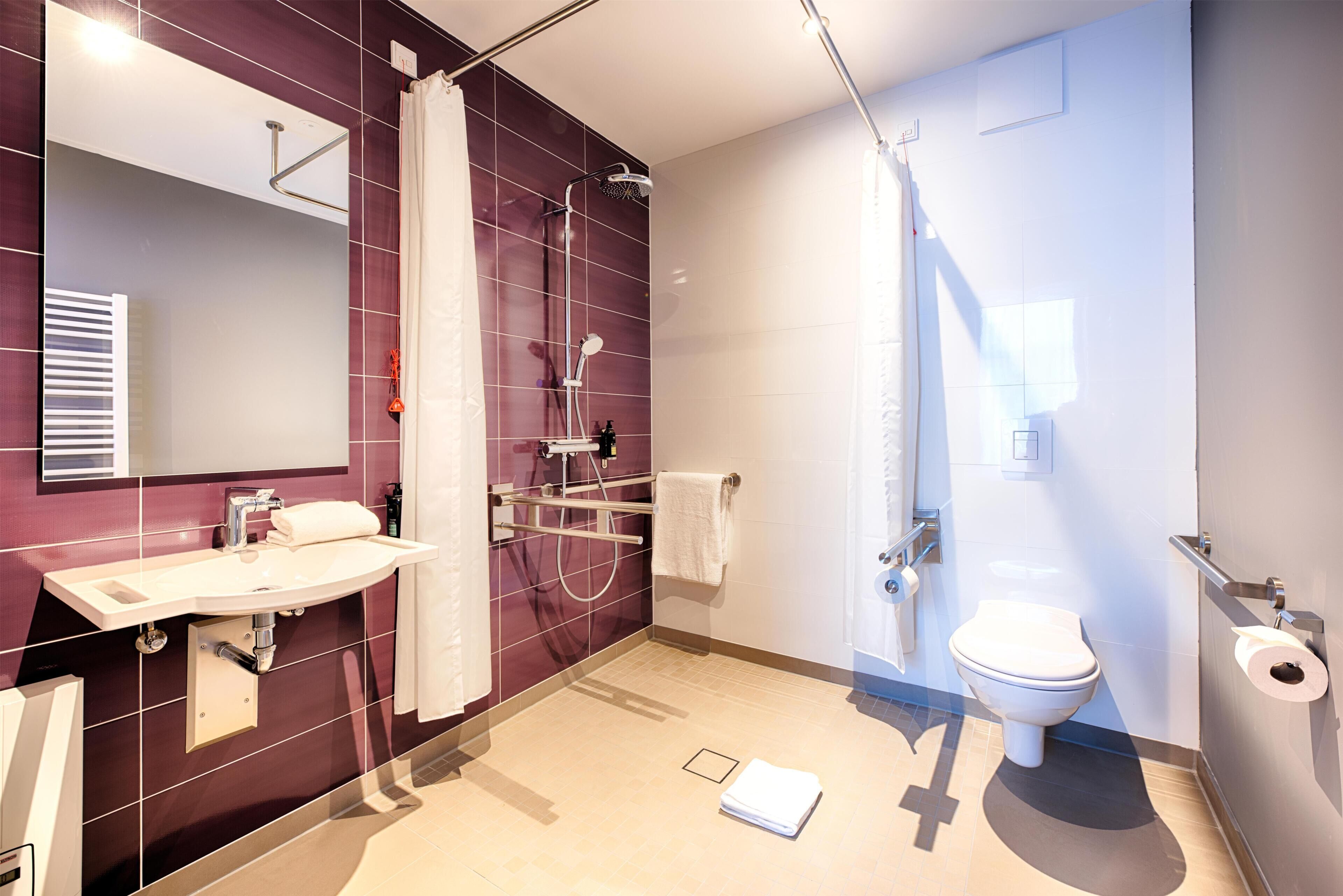 Un baño moderno con ducha, inodoro, lavamanos y espejo.