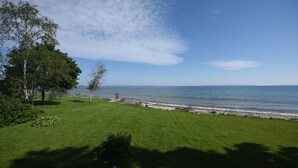 A grassy area with a view of the sea and a clear sky. - Beachfront Cabin on Straits of Mackinac  (Mackinaw City)