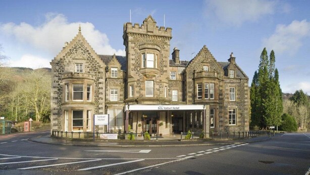 A historic stone building with a central tower, bay windows, and a sign for the Bay Tarbol Hotel. - Tarbet Hotel (Arrochar)