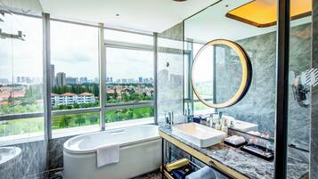 Ein modernes Badezimmer mit Badewanne, Waschtisch und großem Spiegel.