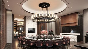 A modern dining area with a circular table, multiple chairs, a central chandelier, and a bar counter. - Pullman Suzhou Taicang  (Suzhou)