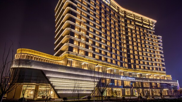 A high-rise hotel with a modern design, featuring multiple balconies and a prominent signage. - Pullman Suzhou Taicang  (Suzhou)