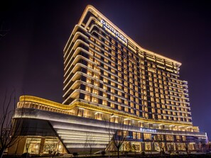 A high-rise hotel with a modern design, featuring multiple balconies and a prominent signage. - Pullman Suzhou Taicang  (Suzhou)