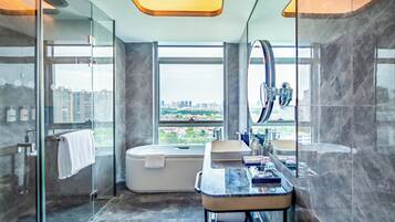 Un baño moderno con ducha de vidrio, bañera y tocador con espejo.