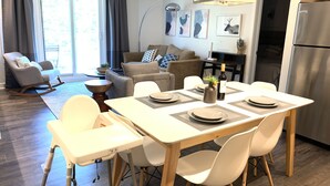Un soggiorno moderno con zona pranzo, cucina e un'ampia finestra.