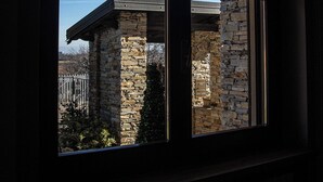 A window with a stone wall and a metal roof structure visible outside. - Casa nel Bosco con Sauna (Cervasca)