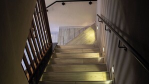 A staircase with wooden steps and metal handrails, leading to a landing with a light fixture. - Casa nel Bosco con Sauna (Cervasca)