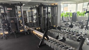 A gym with various weightlifting equipment, including dumbbells and a squat rack. - Zen Hotel Quito (Quito)