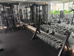 A gym with various weightlifting equipment, including dumbbells and a squat rack. - Zen Hotel Quito (Quito)