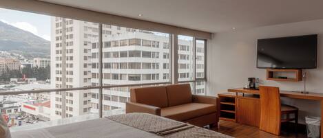 Una habitación de hotel moderna con una cama grande, un sofá, un escritorio y una televisión.
