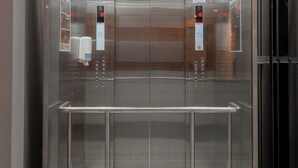 An elevator with a metallic interior, control panel, and illuminated ceiling. - Zen Hotel Quito (Quito)