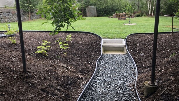 A garden with a gravel path, a small plant, and a hose. - Quiet, large private backyard, fully equipped, dreamy beds! 
Short or long term. (Halifax)