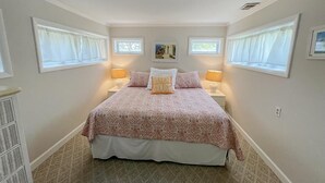 Un dormitorio con una cama grande, dos lámparas de noche y una ventana con vistas.