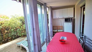 A balcony with a table, chairs, and a small kitchen area. - Residence with swimming pool and private parking space! (LA SEYNE SUR MER)