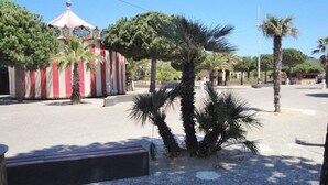 A plaza with palm trees, a red and white striped building, and a bench. - Residence with swimming pool and private parking space! (LA SEYNE SUR MER)