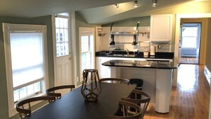 Una cocina amplia con una isla grande, sillas de madera y una mesa de comedor.