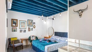 A modern bedroom with a blue ceiling, a bed with patterned bedding, a small round table, and a chair. - Sleeps 8, Pet Friendly, Garden & Roof Terrace (Split)