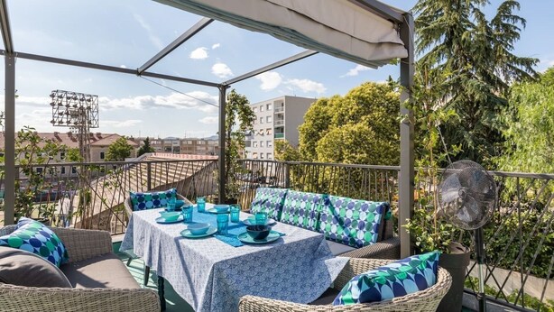 An outdoor patio with wicker furniture, a table set with blue and white tablecloths, and a fan. - Sleeps 8, Pet Friendly, Garden & Roof Terrace (Split)
