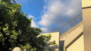A staircase with white balustrades and a metal handrail, leading to a building with a modern design. - Sleeps 8, Pet Friendly, Garden & Roof Terrace (Split)