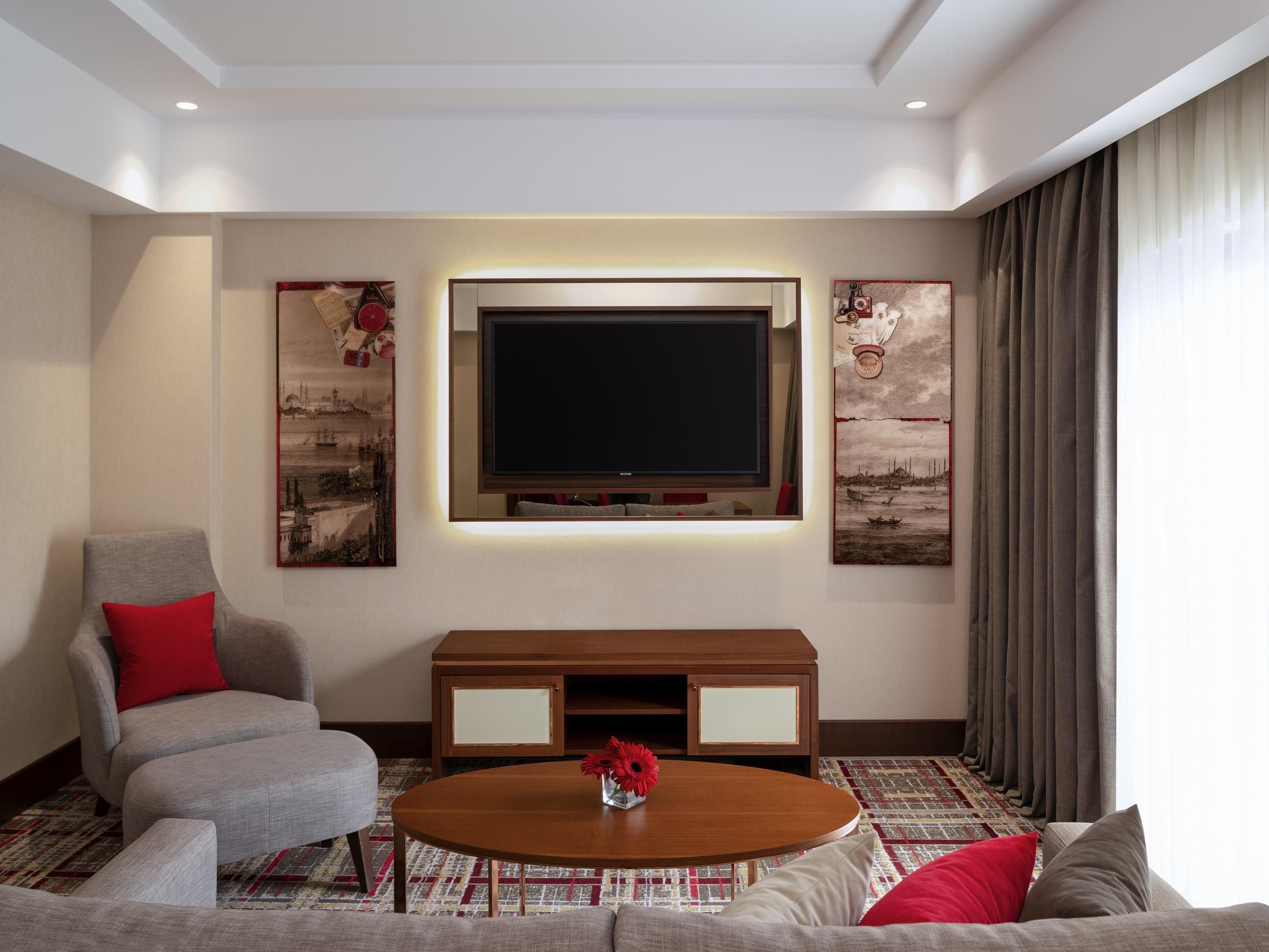 Un salon moderne doté d’un téléviseur à écran plat, de sièges confortables et d’œuvres d’art décoratives.
