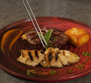 A plate with grilled meat, roasted potatoes, and grilled vegetables.
