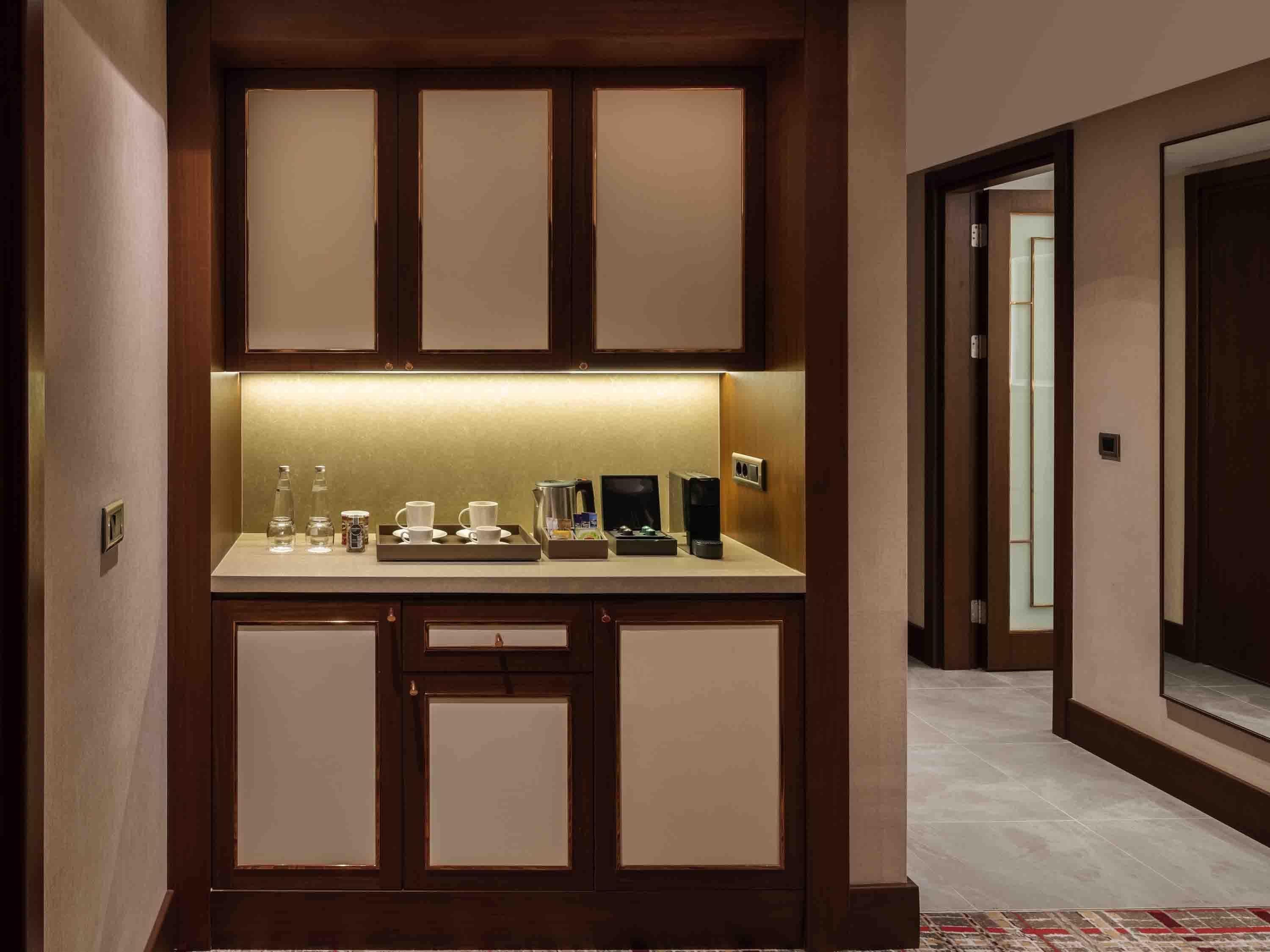 Una kitchenette compacta con una encimera, una cafetera y un hervidor.