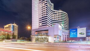 A modern hotel with a curved facade, multiple floors, and illuminated signage. - Mercure Shijiazhuang People Square (Shijiazhuang)