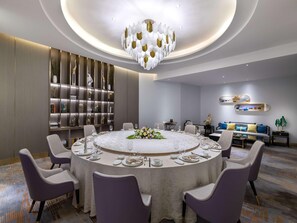 A modern dining area with a round table set for six, surrounded by purple chairs. - Mercure Shijiazhuang People Square (Shijiazhuang)
