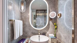 A modern bathroom with a round mirror, a sink, and a towel rack. - Mercure Shijiazhuang People Square (Shijiazhuang)