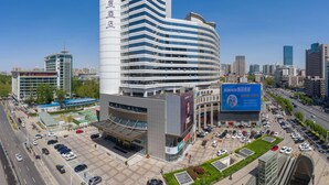 A modern hotel with a curved facade, multiple floors, and a prominent vertical sign. - Mercure Shijiazhuang People Square (Shijiazhuang)