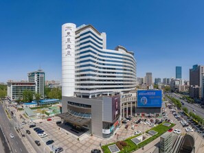A modern hotel with a curved facade, multiple floors, and a prominent vertical sign. - Mercure Shijiazhuang People Square (Shijiazhuang)