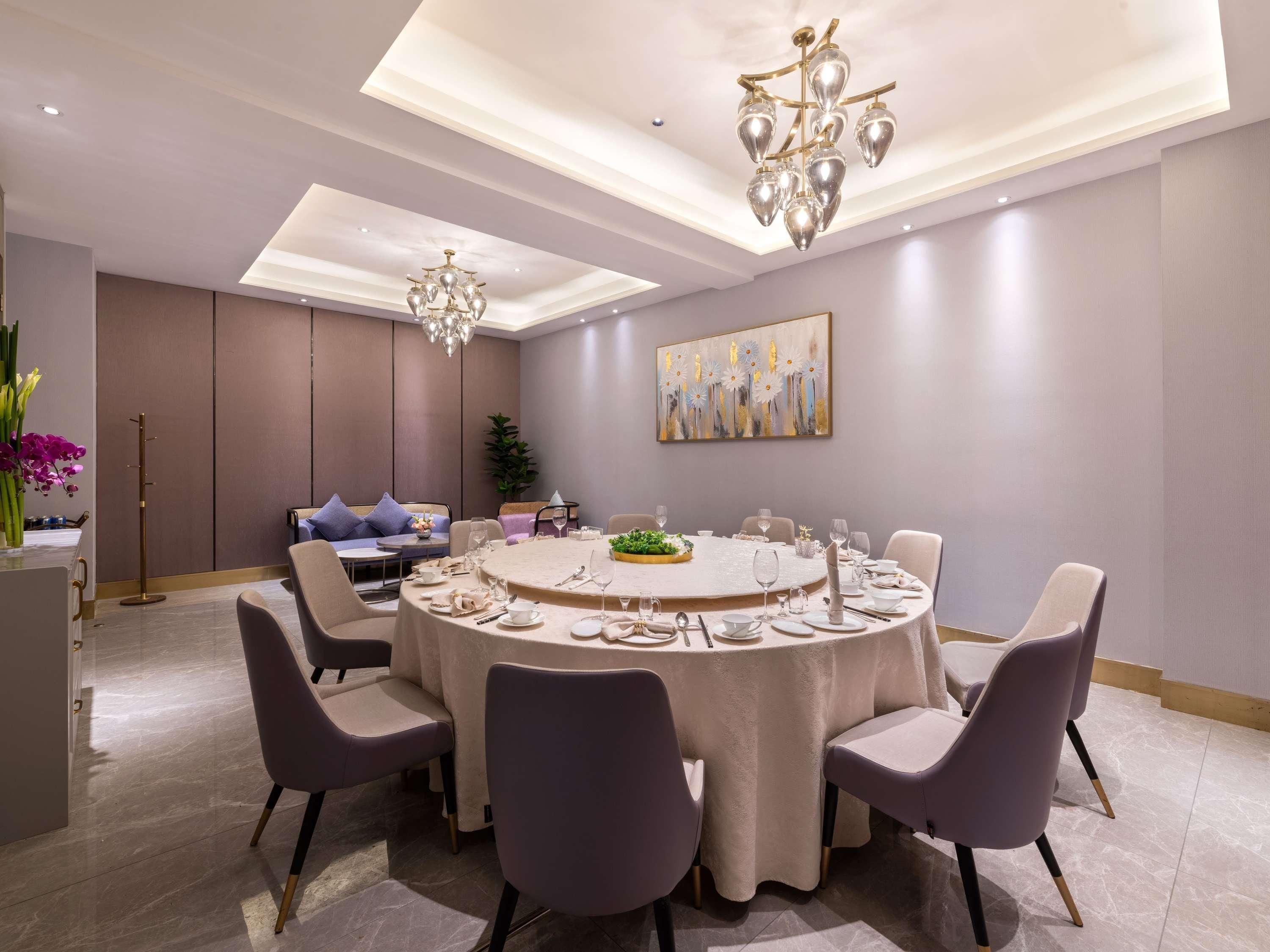 Een moderne eetkamer met een ronde tafel voor zes personen, omringd door zes stoelen.