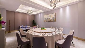 A modern dining room with a round table set for six, surrounded by six chairs.