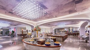A spacious hotel lobby with a central reception desk, a large chandelier, and a buffet area. - Mercure Shijiazhuang People Square (Shijiazhuang)