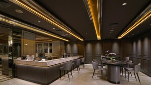 A modern hotel lobby with a marble reception desk, seating area, and a large mirror. - Mercure Surabaya Manyar (Surabaya)