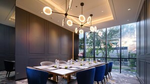 A conference room with a long table, blue chairs, and a modern chandelier. - Mercure Surabaya Manyar (Surabaya)