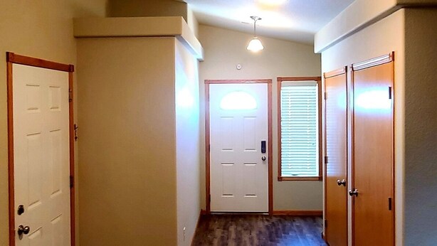 A hallway with wooden flooring, white doors, and a ceiling light fixture. - Townhouse in a quiet culdesac, easy access to all Black Hills area attractions. (Rapid City)