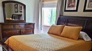 A bedroom with a bed, dresser, and a ceiling light fixture. - Townhouse in a quiet culdesac, easy access to all Black Hills area attractions. (Rapid City)