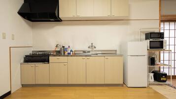 A compact kitchen with a stove, sink, and microwave.