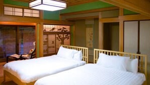 Una tradizionale stanza in stile giapponese con due letti di legno, pavimento in tatami e pannelli shoji.